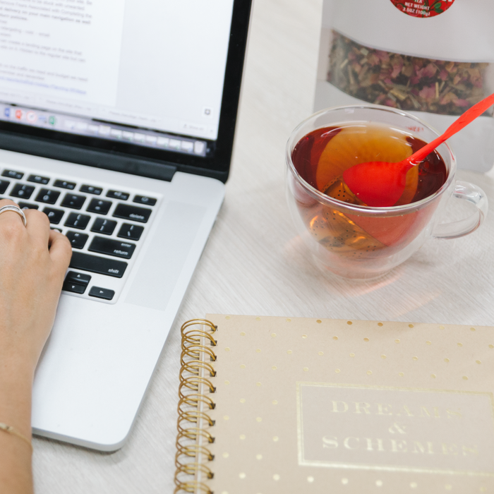 Woman working with a cup of Teami Blends Bloom Tea