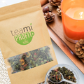 Teami Profit Tea Blend with pine cones and a candle